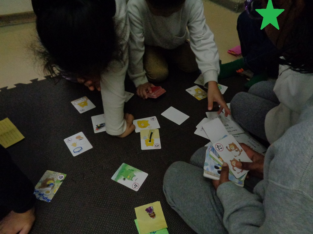 カルタ取りをして遊ぶ子どもたち