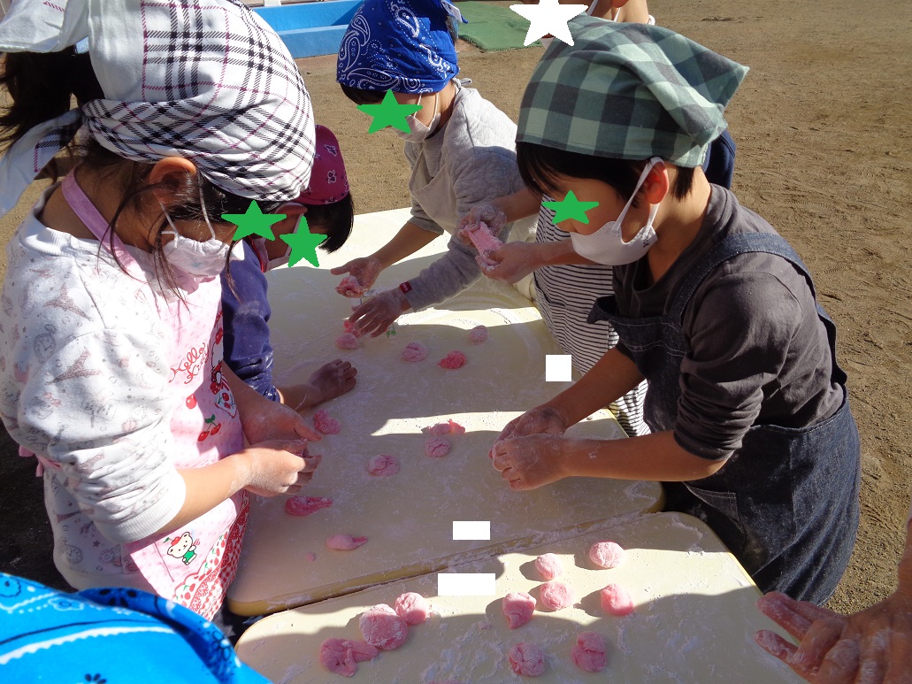 赤色のお餅を丸めている子どもたち