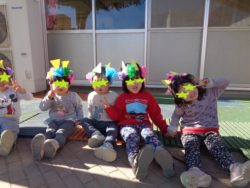 子どもたちがお花紙を丸めて鬼のお面を作った