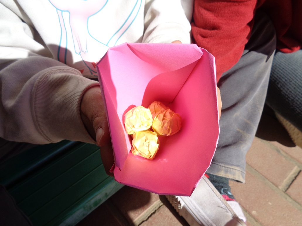 子どもたちが折り紙を丸めて豆を作った