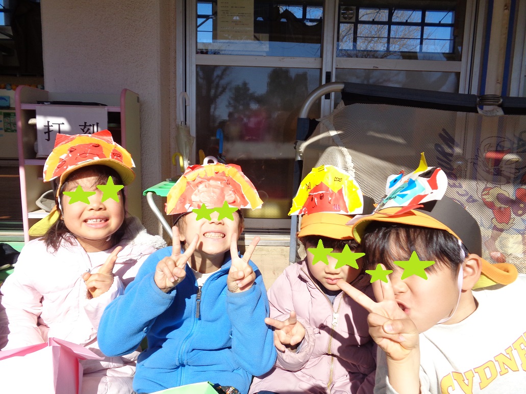 子どもたちが折り紙をちぎって鬼のお面を作った