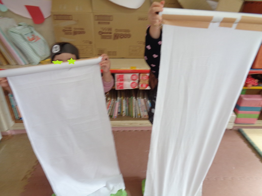 忍者ごっこで布に隠れている