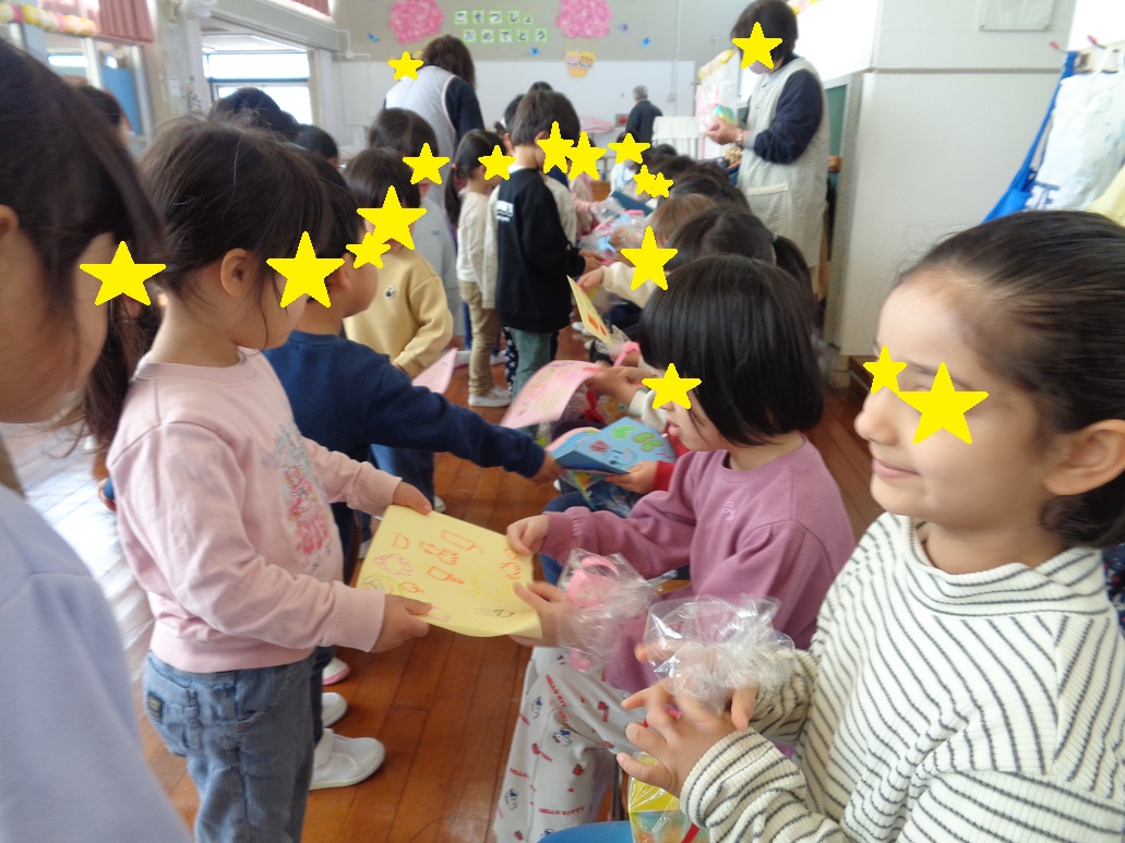 自分たちで作ったプレゼントを年長児に渡している