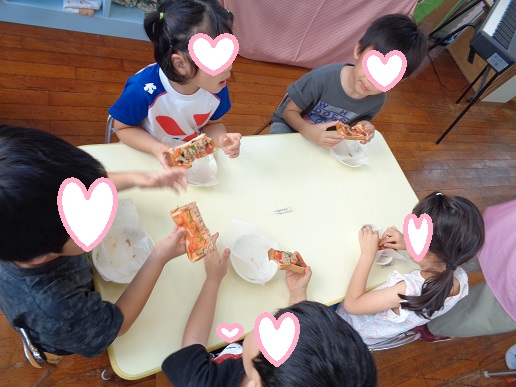 自分で作ったピザを喜んで食べる様子。