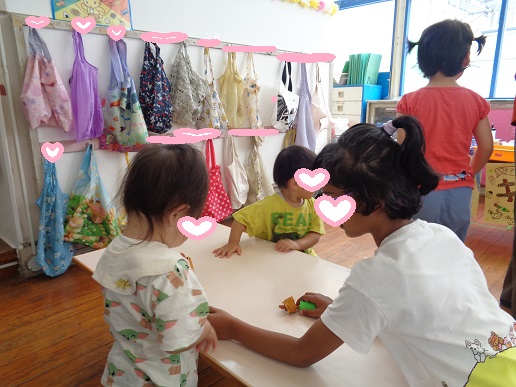 焼き鳥の手作りおもちゃを小さいクラスの子に優しく渡す様子