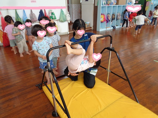 鉄棒にぶら下がる3歳児