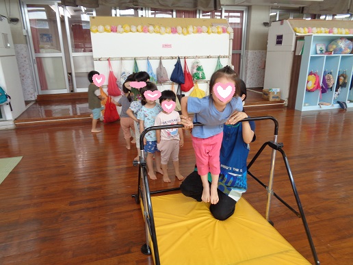 鉄棒に飛びつく3歳児