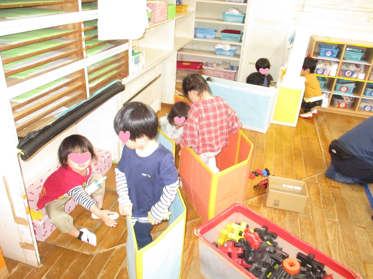 段ボールの仕切りで家を作ってままごとをしている