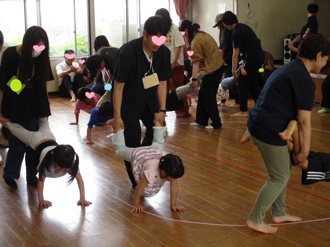 親が子どもの足を持って手押し車をしている