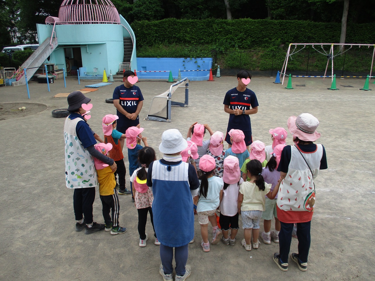 サッカー教室で子どもたちがコーチの話を聞いている