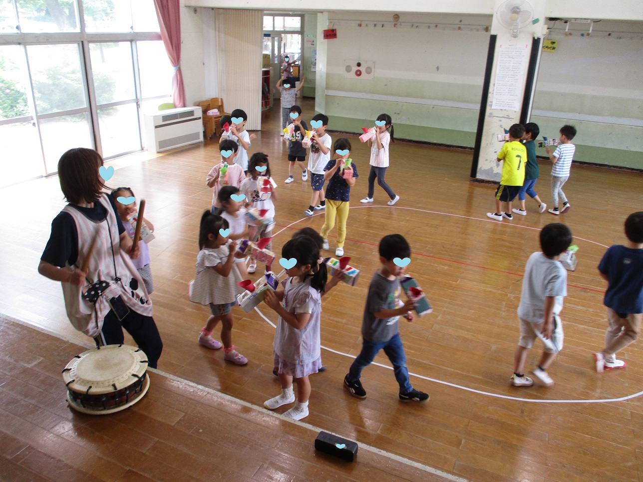 太鼓のリズムに合わせて、手作りの笛を吹きながら歩いている