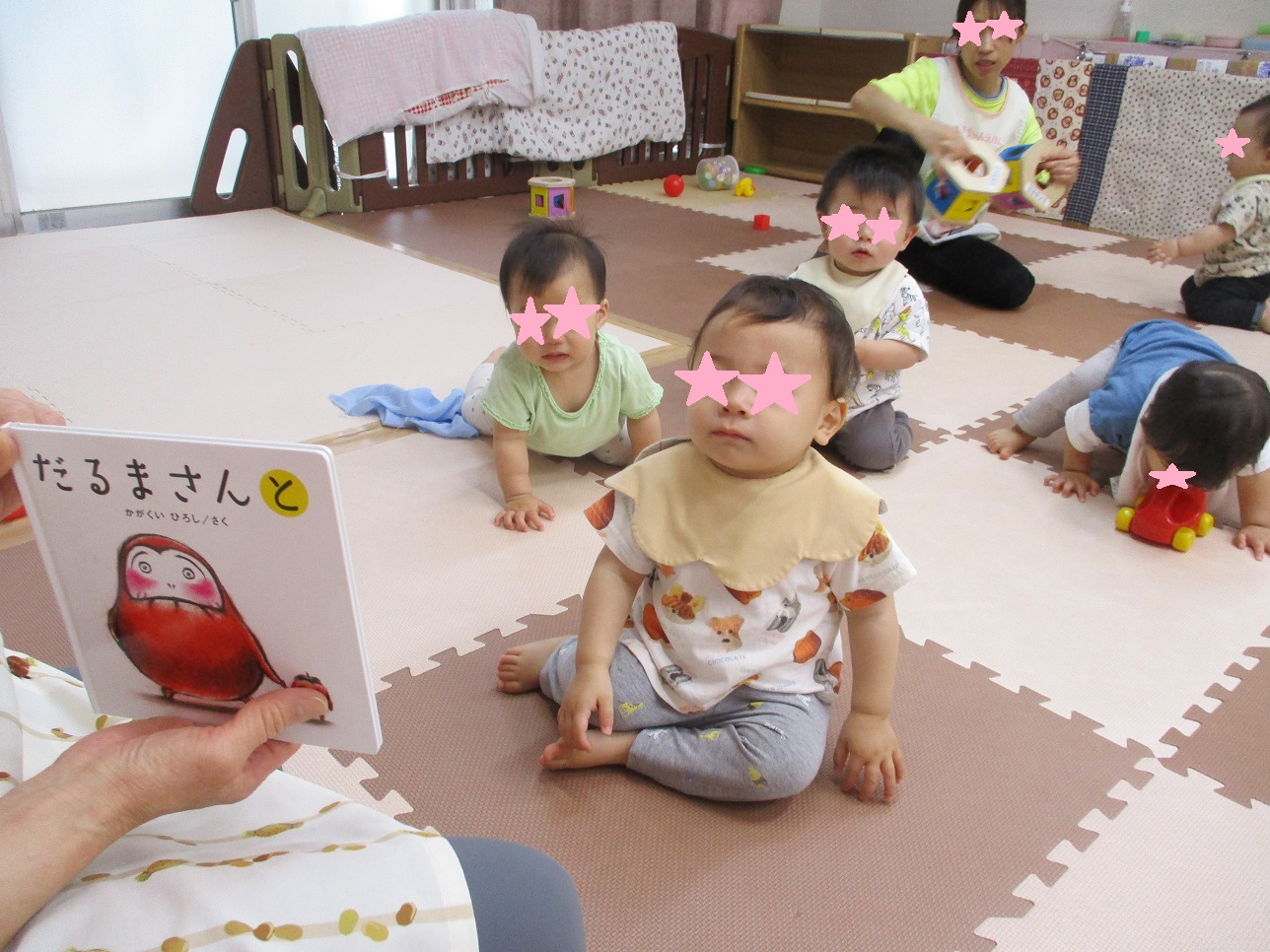 赤ちゃんが座って絵本を見ている