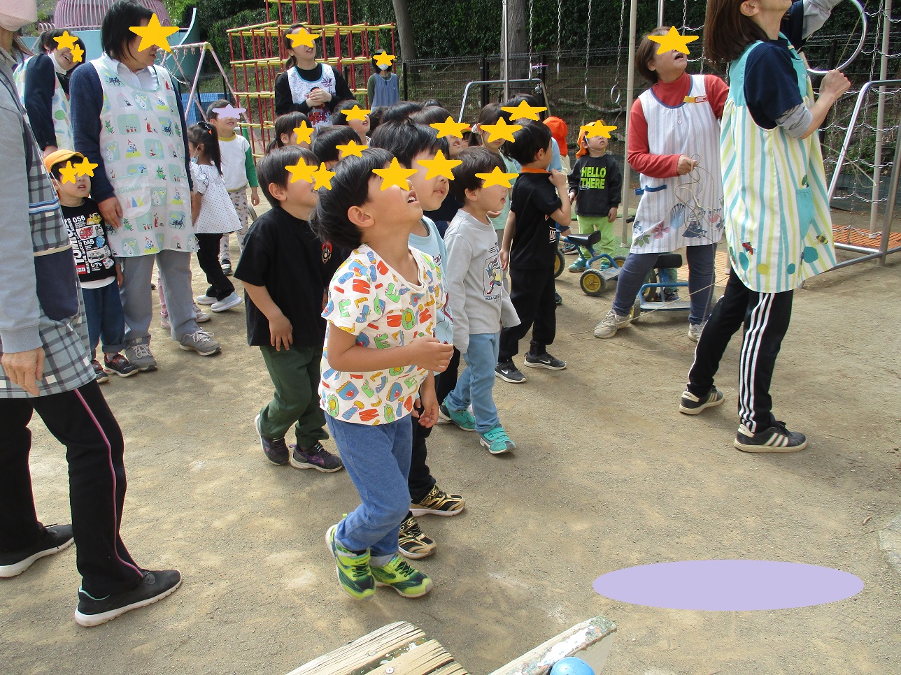 子どもたちと大人のが上を見上げている