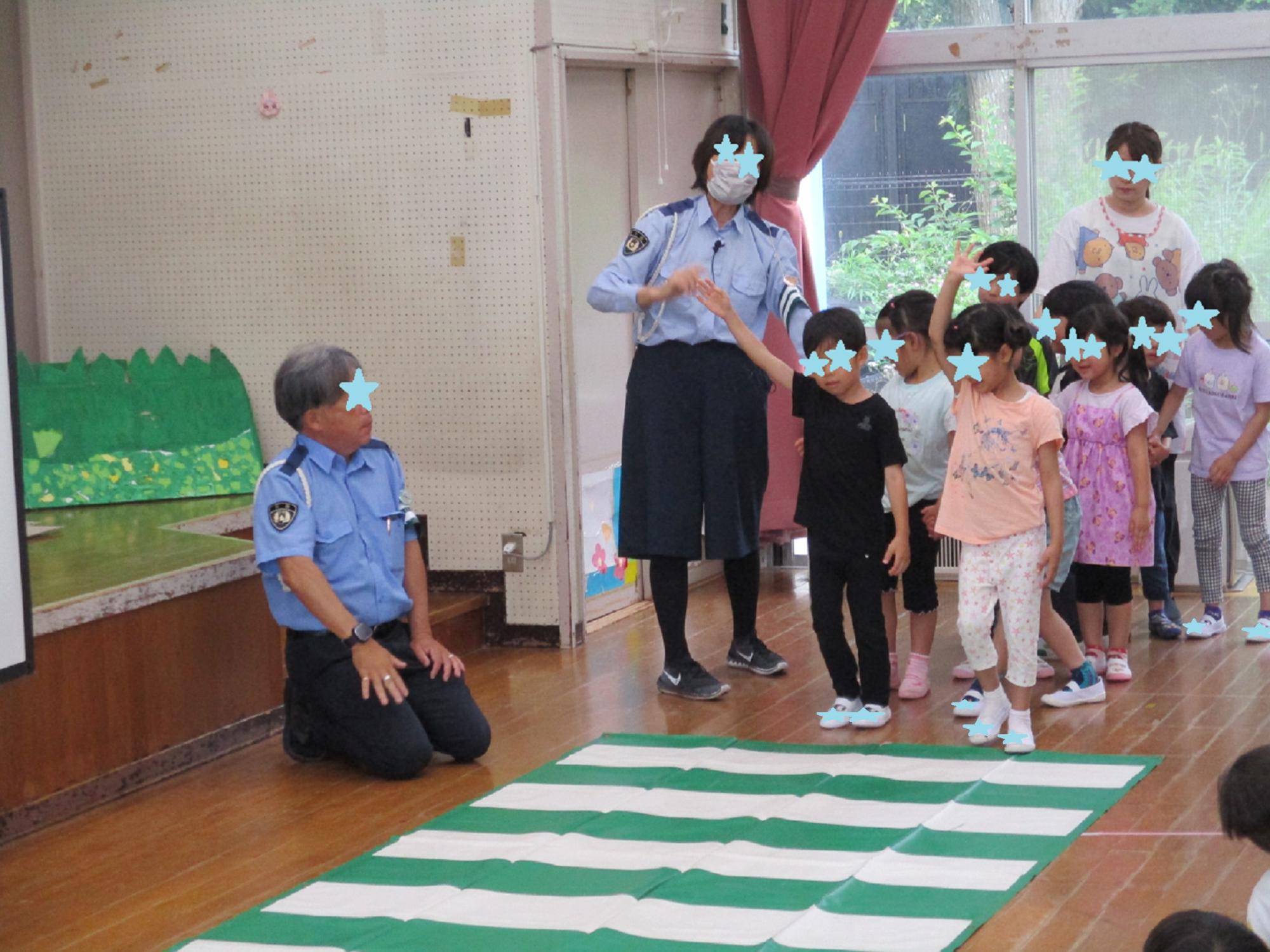 緑と白の横断歩道マットの前で手をあげる子供たち