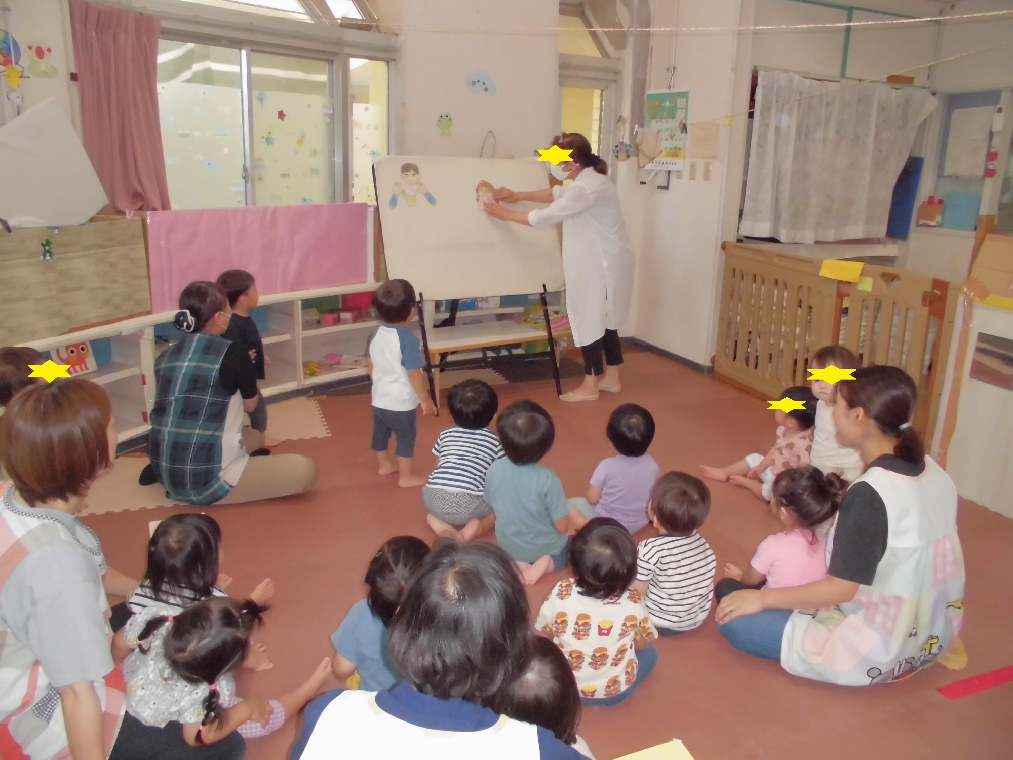お話会でパネルシアターを見る1歳児