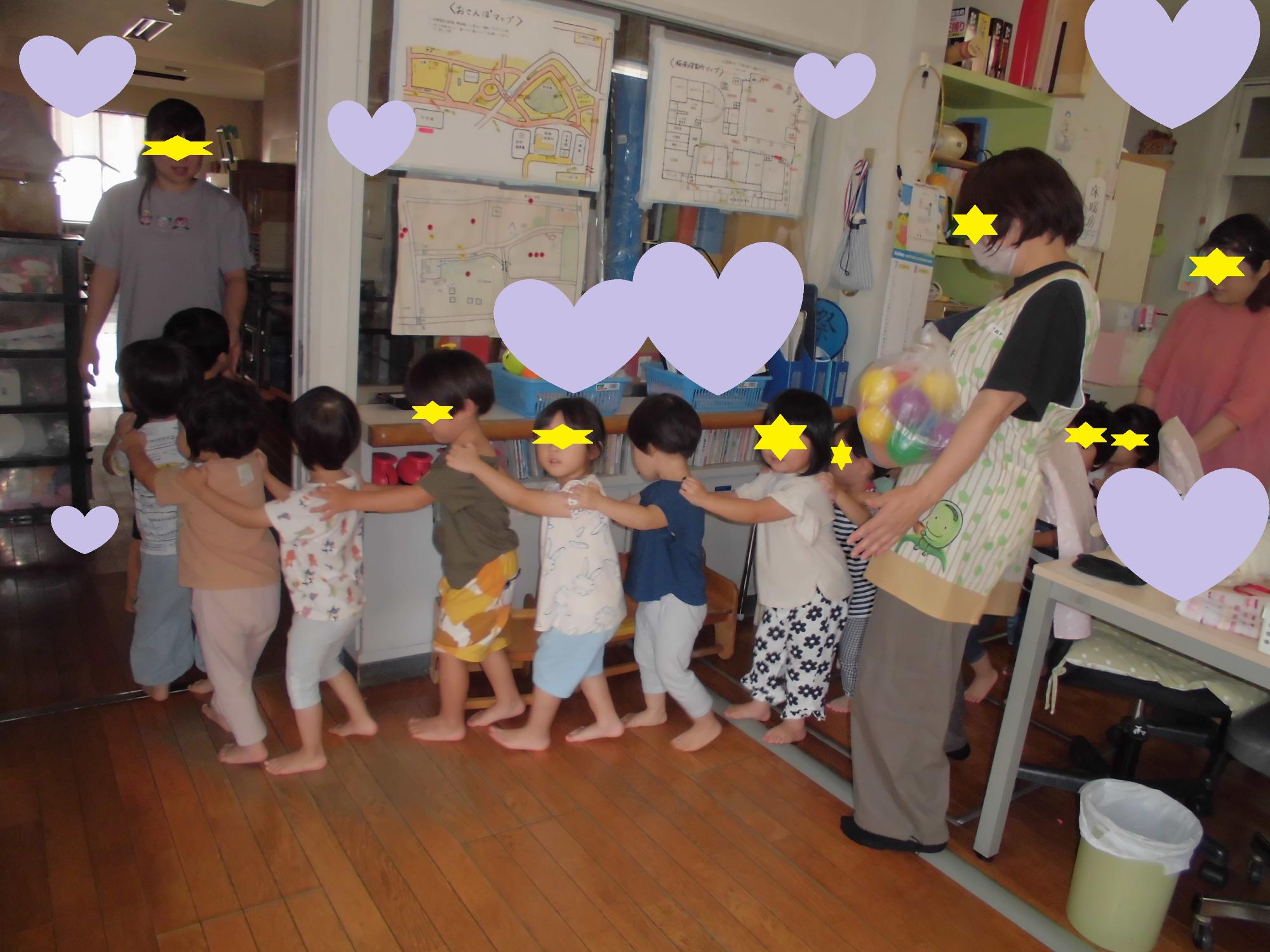 電車のようにつながり室内探検をする2歳児