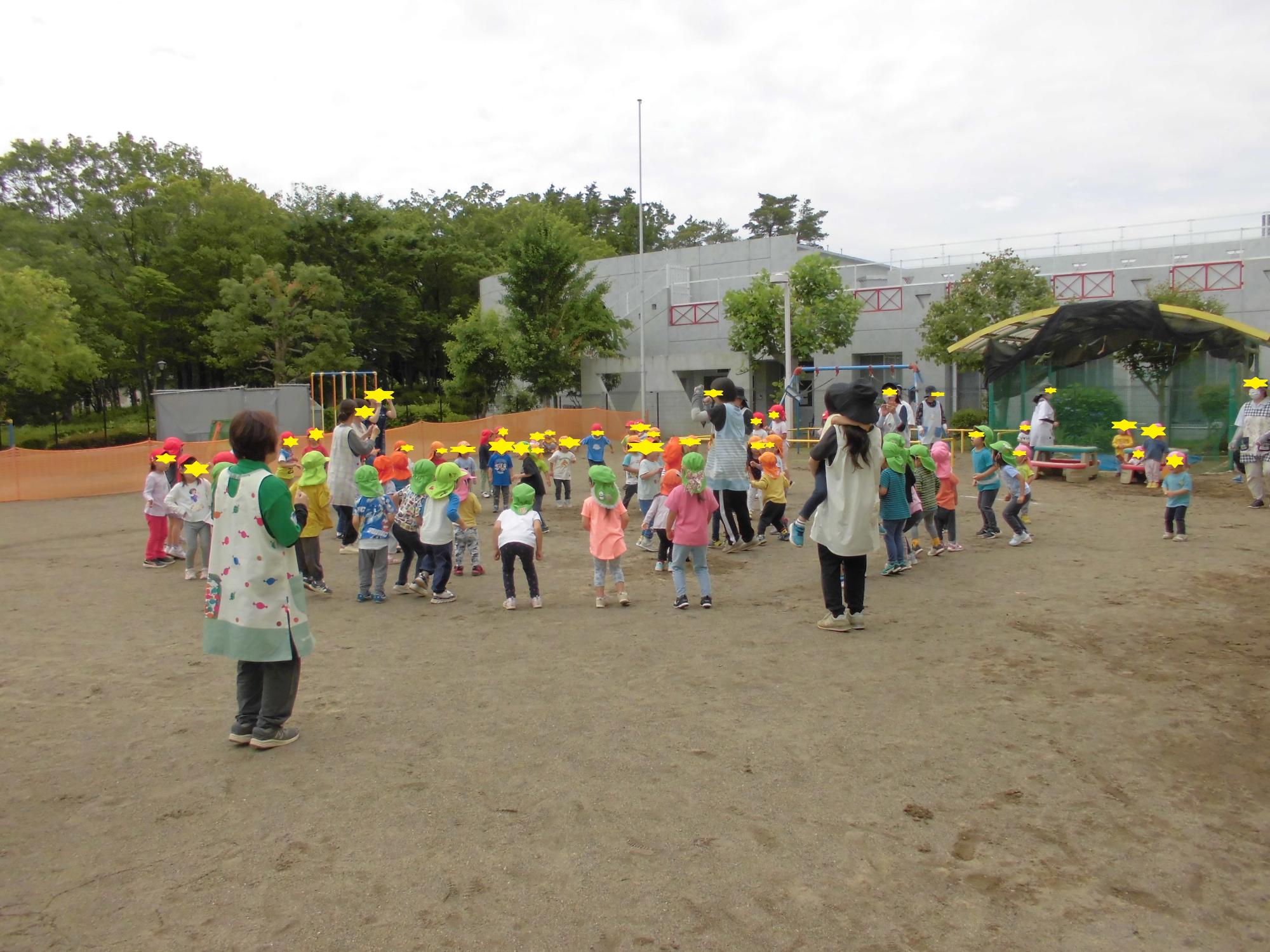 なつまつりごっこの盆踊りを所庭でおどる3歳児から5歳児クラス